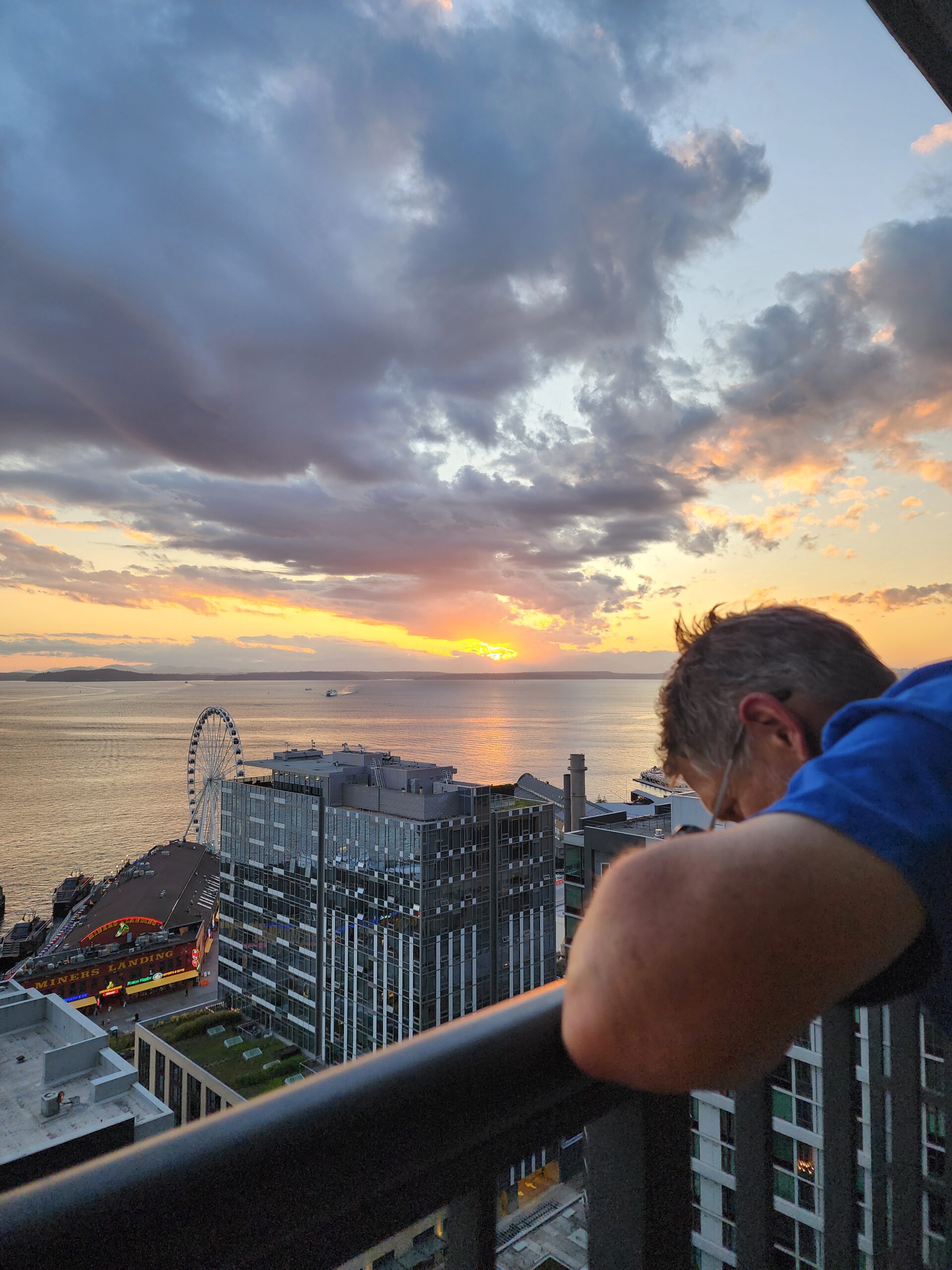 Man standing on a balcony looking out at the view—reflecting the quiet, meaningful moments of travel and slowing down to take it all in.