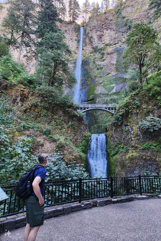 Man looking up at the waterfall. Multnomah Falls, Oregon