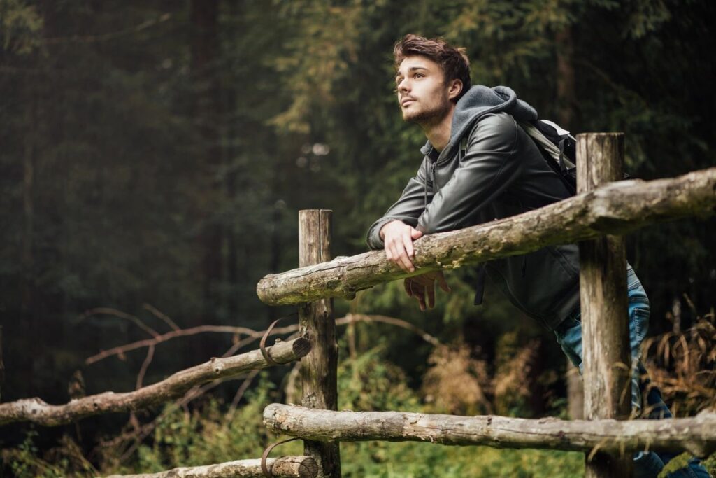 Man in 40s on a hike looking out a nature