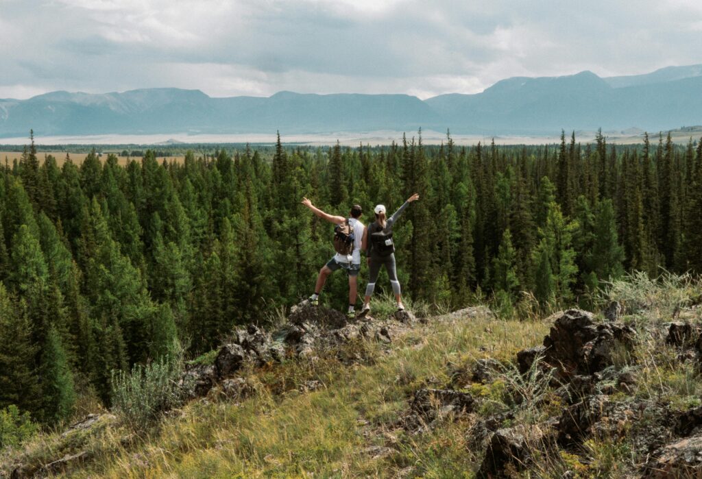 A couple embracing adventure, standing at the summit of a hike, ready to take on new challenges in midlife.  Photo by Сергей Скрынник 