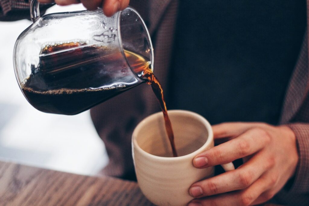 Close-up of coffee being poured into a ceramic mug, representing mindful routines and a slower pace of life
