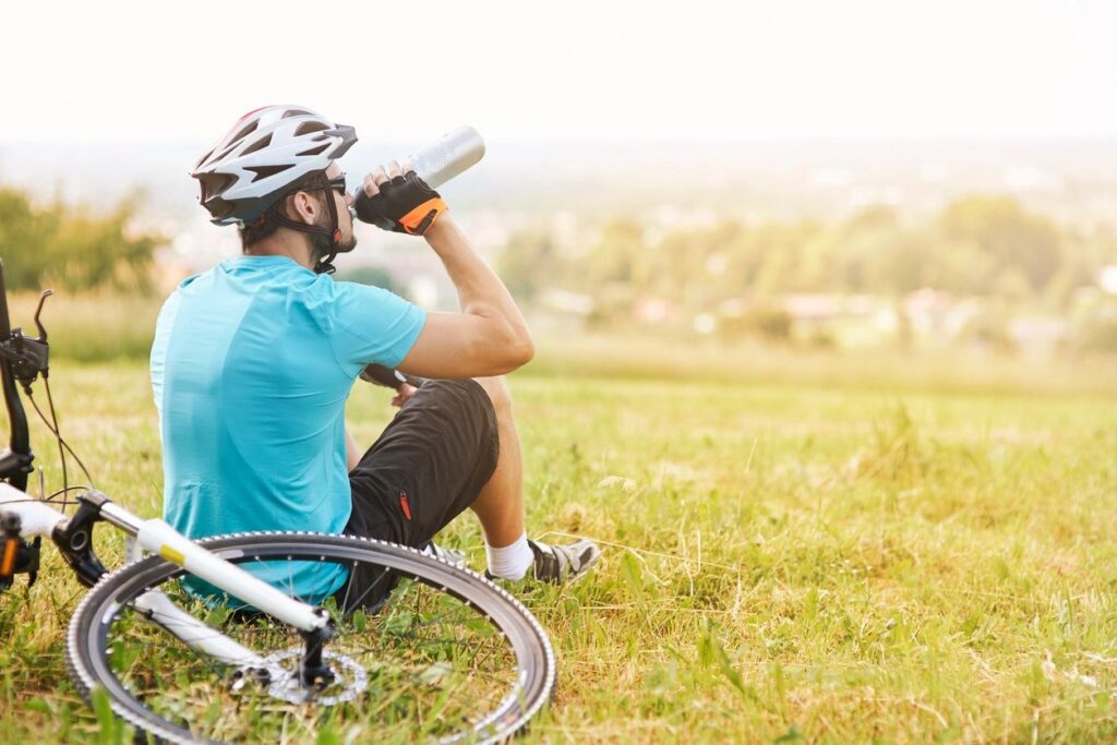 Essential beginner biking gear including helmet, water bottle, bike lock, and repair tools