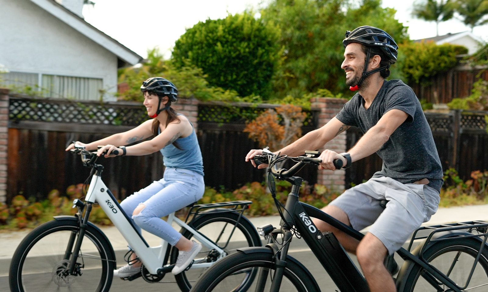 Two people riding bikes side by side, smiling and enjoying a relaxed outdoor ride on a sunny day
