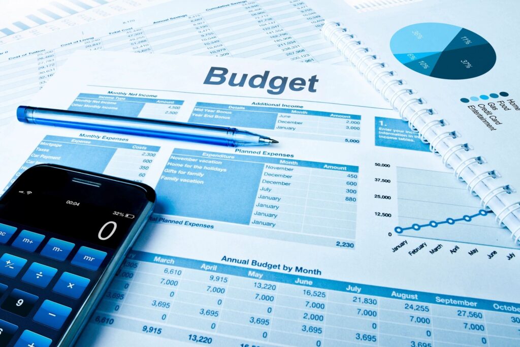 Budget sheet with charts, calculator, and pen on a desk, symbolizing organizing finances without needing perfection.
Would you like me to als