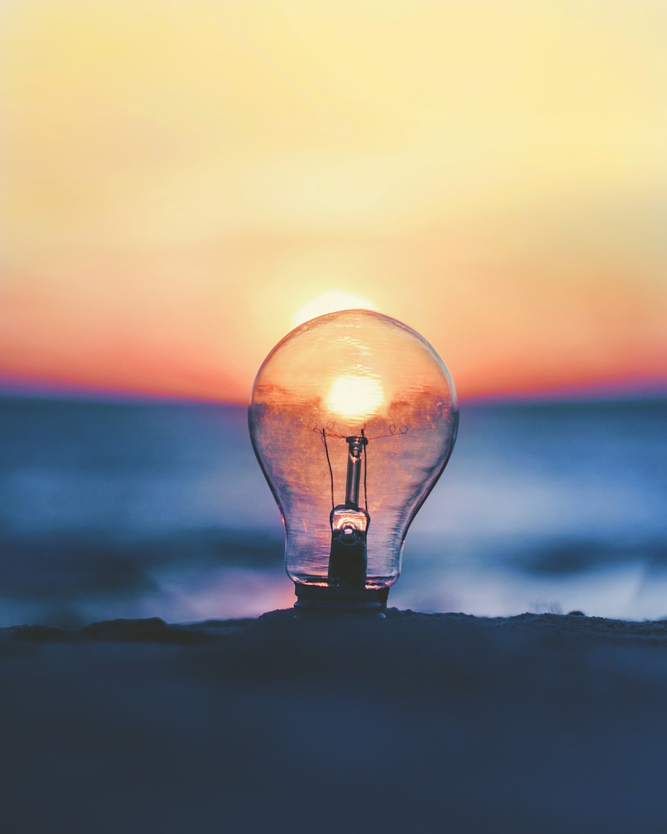 Lightbulb glowing with sunset inside – symbol of creativity, growth, and new ideas.
