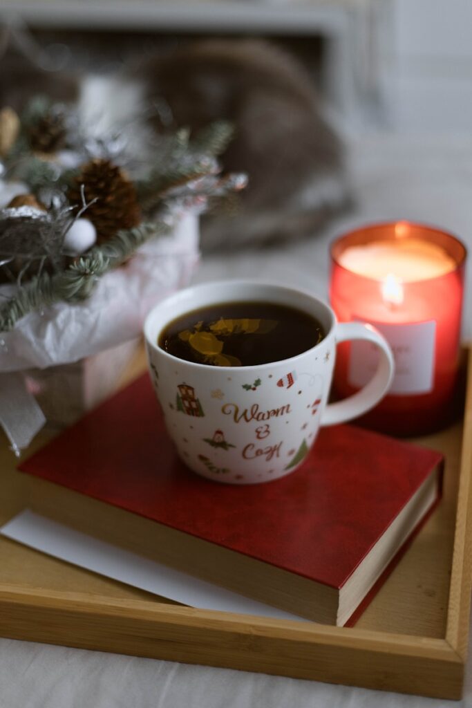 Warm mug and open notebook on a winter table symbolizing a calm holiday reset and mindful eating.