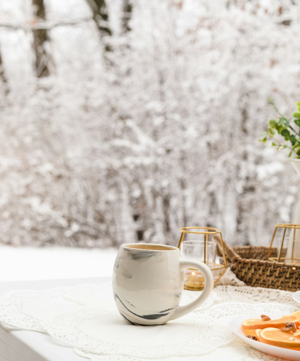 Warm mug and open notebook on a winter table symbolizing a calm holiday reset and mindful eating.