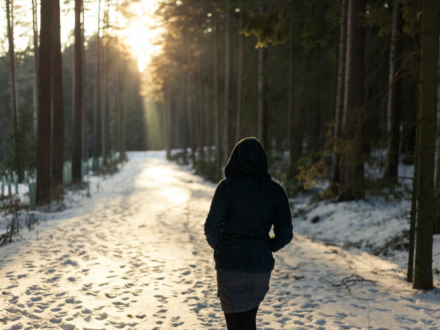 A woman walking on a quiet winter trail, symbolizing small steps, clarity, and year-end reinvention.