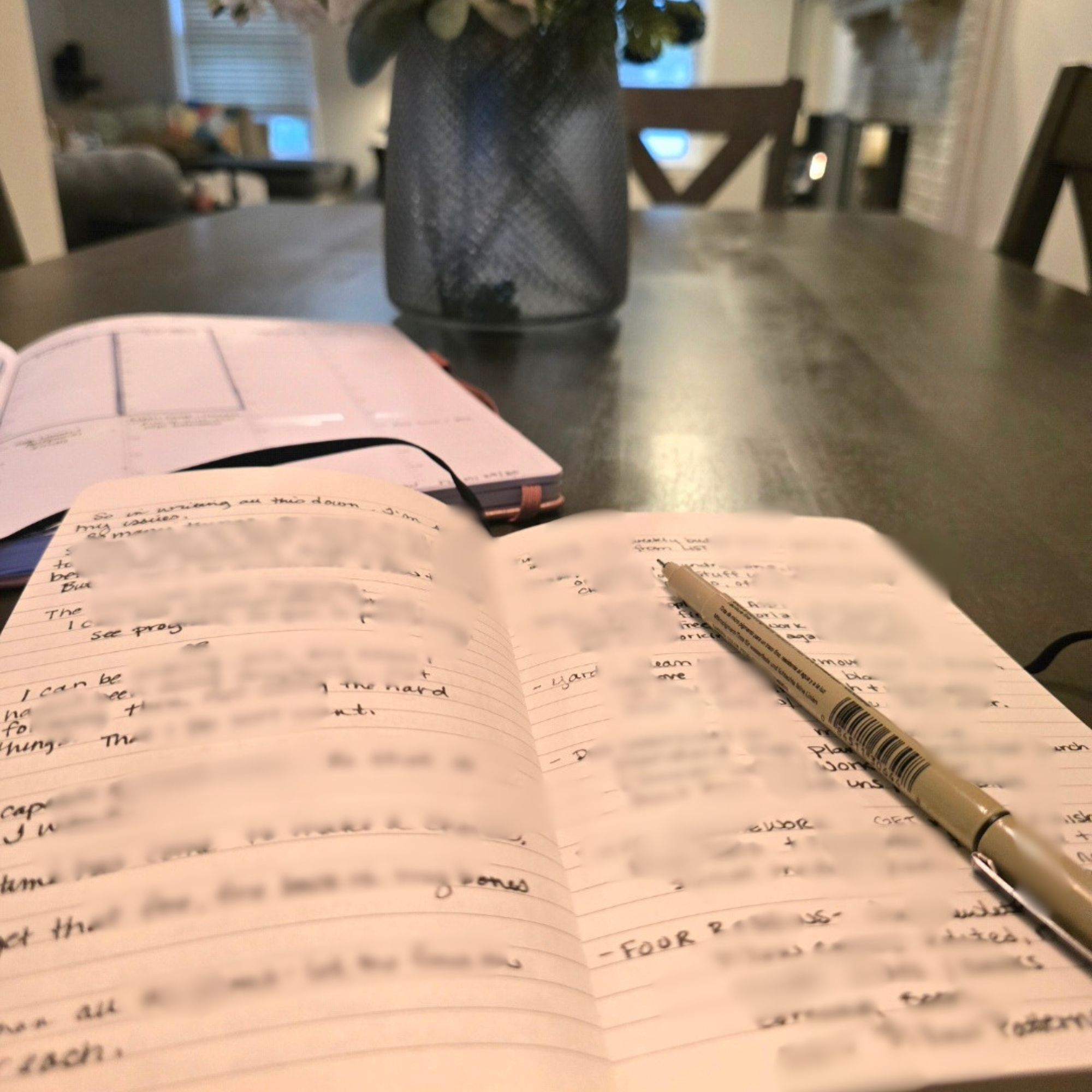 Handwritten journal open on a dining table with a full list across life areas — the starting point for getting unstuck